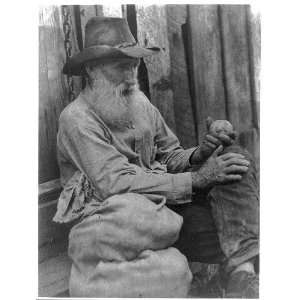  Old man holding potato,wearing a hat,beard,sitting,c1930 